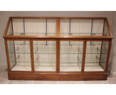 A large Edwardian mahogany haberdashers shop display cabinet, with two hinged sloping glazed doors opening to a painted inter
