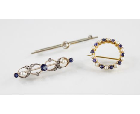 A diamond, sapphire and pearl set bar brooch, comprising three round mixed cut sapphires claw set to a swirling border surrou