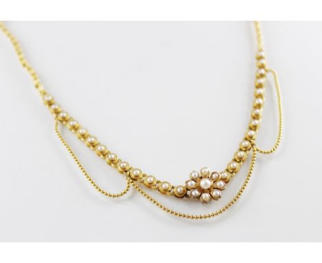 An Edwardian pearl set collarette, comprising a central floral pendant set with pearls, 12mm diameter, applied pad stamped ?1