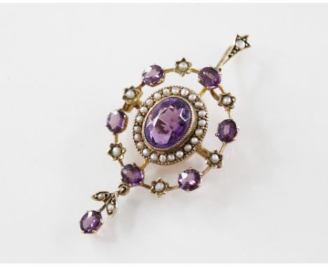 An Edwardian amethyst and seed pearl set pendant/brooch, comprising a central oval mixed cut amethyst with a seed pearl borde
