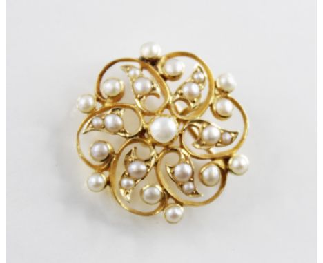 An Edwardian pearl set brooch/pendant, the pierced floral design frame set with half pearls throughout, hinged pin and loop f