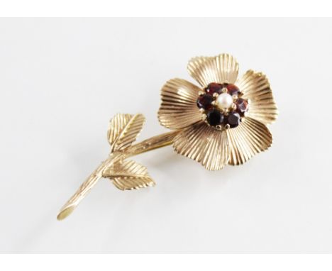 A garnet and pearl set floral design brooch, central cluster comprising a cultured pearl with a surround of six mixed cut gar