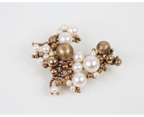 A 1970's 9ct gold pearl set cluster brooch, comprising graduated gold spheres of plain polished and textured decoration, inte