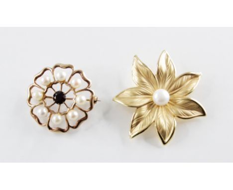 A 9ct gold garnet and pearl set floral brooch, comprising a central mixed cut garnet with a surround of eight cultured pearls