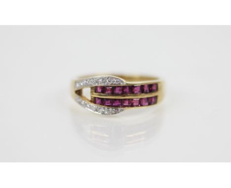 A ruby and diamond set 18ct gold ring, the buckle design ring set with square cut rubies and mixed cut diamonds, all set to a
