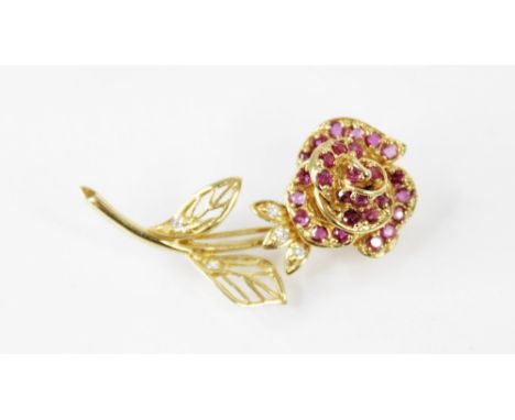 A diamond and ruby set 18ct gold floral brooch, designed as a rose, the petals set with round mixed cut rubies, the leaves se