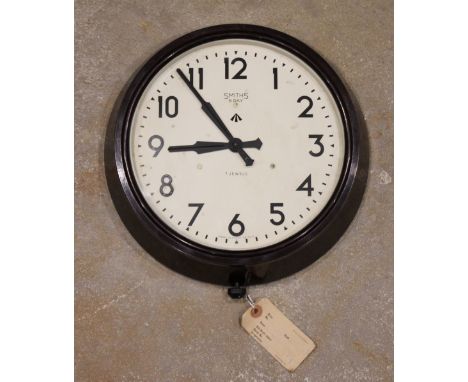 A military issue Smiths Bakelite eight day '7 jewels' wall clock, mid 20th century, with army issue tag 'G1064', the 22cm dia