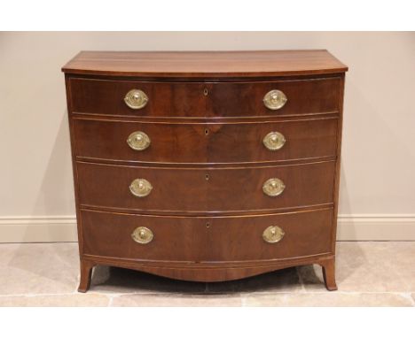 An early 19th century mahogany bow front chest of drawers, formed of two short of three long graduated drawers, applied with 