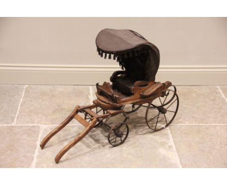 A Victorian wooden model of a horse drawn carriage, the canvas canopy enclosing a button back interior, upon the beech wood b