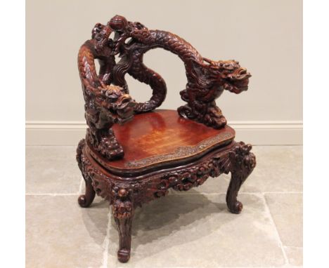 A Chinese carved hardwood dragon tub chair, early 20th century, the back formed from a pair of carved intertwined scaly drago