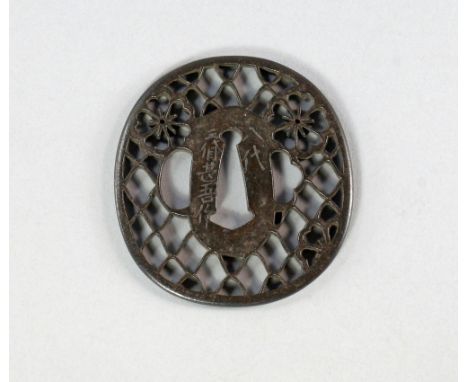 A Japanese bronze tsuba, 18th/19th, pierced with stylised flower heads on lattice work, signed to edge, 7.3cm diameter