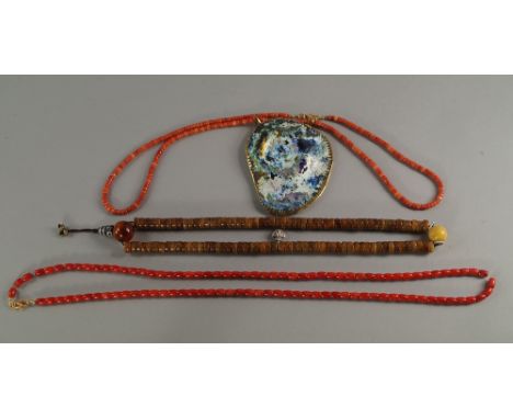 Two coral necklaces, 20th century, one hung with a glass plaque framed in a  metal surround, 98 cm and 92cm long approx., tog