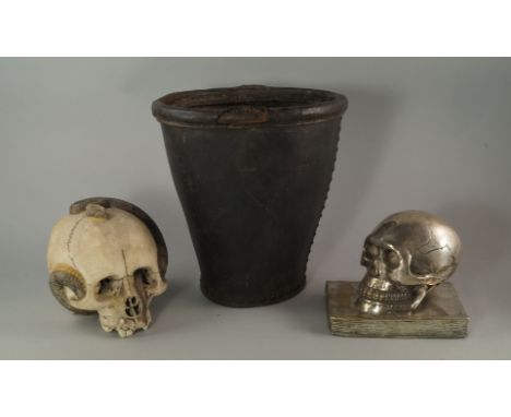 A silver plated model of a skull resting on a book, 20th century, 14cm high, together with a ceramic model of a skull with a 