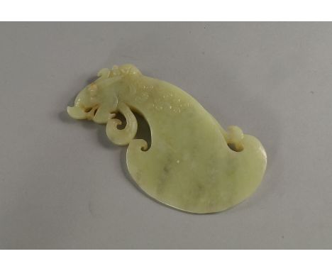 A Chinese jade archaic style axe head, 20th century, carved and pierced with a dragons head and scrolling collar, 16.5cm wide