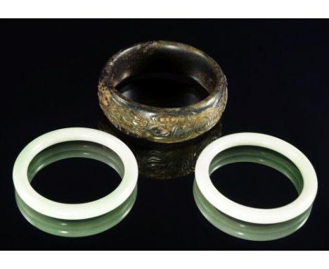 A large Chinese hardstone bangle, 19th/20th century, carved to the edge with bats and coins, 8cm diameter together with a pai