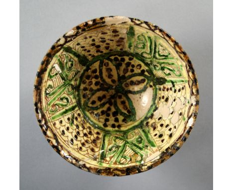 A Nishapur sgraffito splashware pottery bowl, 10th Century, the earthenware body incised with stylised panels of scroll work 