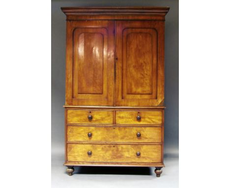 A Victorian mahogany linen press, 19th century, with shaped panelled cupboard doors, on two short and two long drawers, on tu