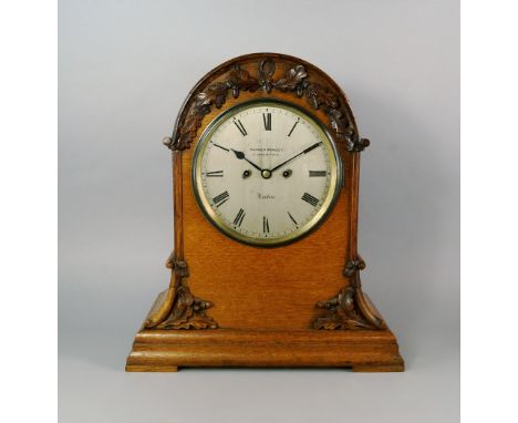 A large Victorian oak mantel clock by Parker Muncey, the rectangular Gothic form case with domed top carved with sprays of ac