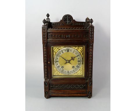 An English or German oak bracket clock, late 19th/early 20th century, the case overall carved in the Gothic taste, the dial w