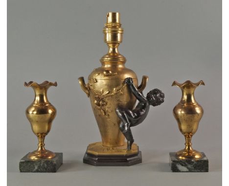 A gilt bronze lamp base, 20th century, of vase form moulded with flowers, a cherub hanging from its handles, on a hexagonal b