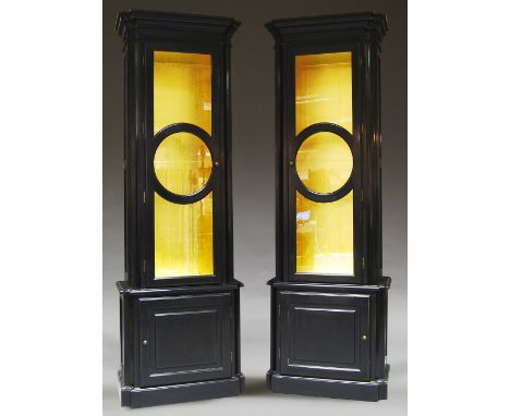 A pair of ebonised and gilded glazed display cabinets, 20th century, the upper tier with glazed doors, above cupboard doors, 