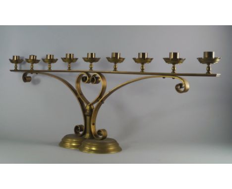 A pair of Victorian brass nine light ecclesiastical candelabra, each sconce of cylindrical form with crenelated drip pan, on 