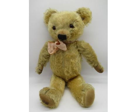 C.1930's Merrythought teddy bear in golden mohair with tag on foot, button in ear, glass eyes, jointed arms and legs, swivel 