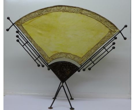 A Chinese style black painted metal and pigskin fire screen