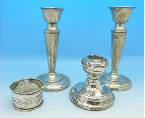 A pair of silver candlesticks, a silver napkin ring and a silver dwarf candlestick