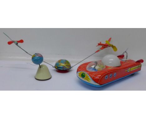 A German tin plate globe and airplane toy, an East European tin plate space car and one other tin plate toy