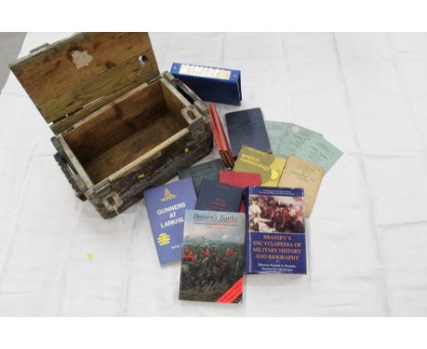 Group of official Army training manuals, circa 1950s, together with other military related books in pine transit box