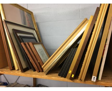 A shelf of framed pictures and prints