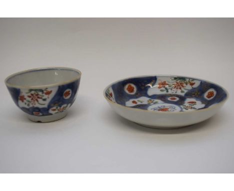 18th century Chinese porcelain tea bowl and saucer with a blue ground and gilt design with panels of flowers in red and green