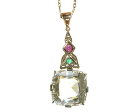 A CUSHION SHAPED FACETED QUARTZ PENDANT IN FOLIATE MOUNT WITH EMERALD AND RUBY ACCENTS ON SILVER CHAIN, QUARTZ APPROX 23 CT++