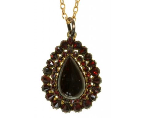 A CLOSED BACK PEAR SHAPED  GARNET CABOCHON PENDANT ON LATER 9CT GOLD CHAIN, THE CENTRAL CABOCHON SET TO A TIERED FACETED GARN