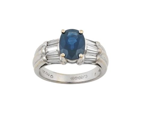 An 18 Carat White Gold Sapphire and Diamond Ringthe oval cut sapphire in a four claw setting, to undulating baguette cut diam