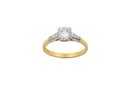 An 18 Carat Gold Diamond Solitaire Ringthe round brilliant cut diamond in a white claw setting, to tapered baguette cut diamo
