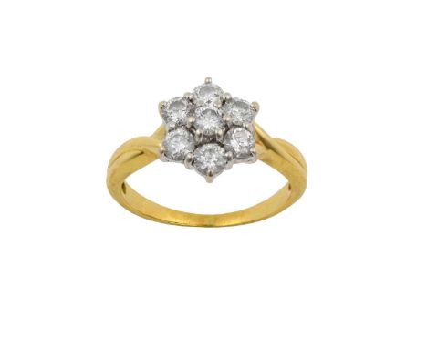 A Diamond Cluster Ringthe central raised round brilliant cut diamond within a border of round brilliant cut diamonds, in whit