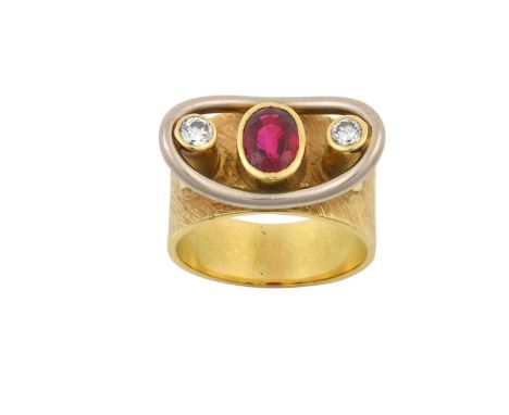 A Ruby and Diamond Ring  the yellow broad textured shank decorated with a raised oval cut ruby flanked by round brilliant cut