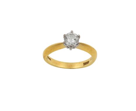 An 18 Carat Gold Diamond Solitaire Ringthe round brilliant cut diamond in a white claw setting, to a yellow tapered shoulder 