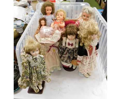 A group of dolls, some with porcelain faces, the others celluloid, contained in a wicker hamper. 