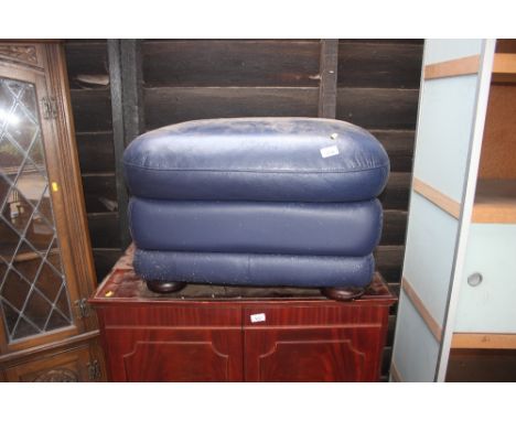 A blue leather upholstered foot stool