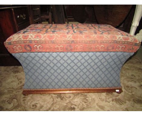 A vintage ottoman of rectangular form with concave sides, carpet top and bun feet.