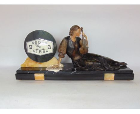 A good Art Nouveau black slate figural mantle clock, the styised two train dial aside a cast metal reclined lady holding a vi