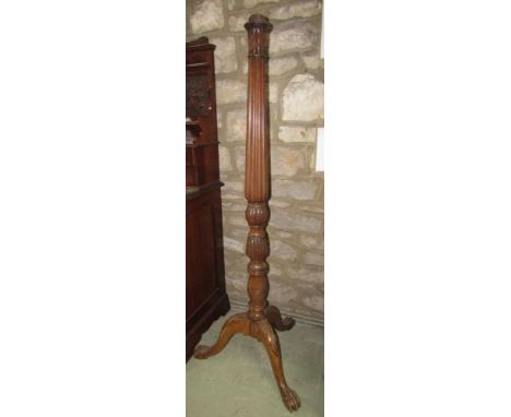 A mahogany lamp standard with turned and fluted column and a tripod base with acanthus carving and a claw support.