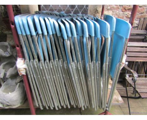 Thirty nine folding pop chairs with light blue coloured moulded plastic seats and back rails supported by tubular frames.