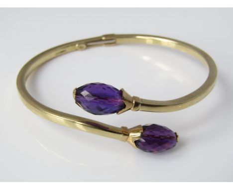 A hinged 9ct gold torque bangle with amethyst coloured faceted stones, 11.5g