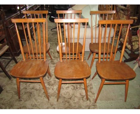 Set of six Ercol mid elm stick back dining chairs with spindles running from the bar top to the back structure, elm seats