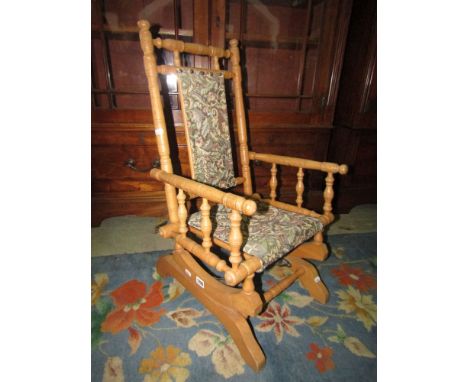 An American rocking chair unusually in beechwood and of child's size with carpet type seat and back.