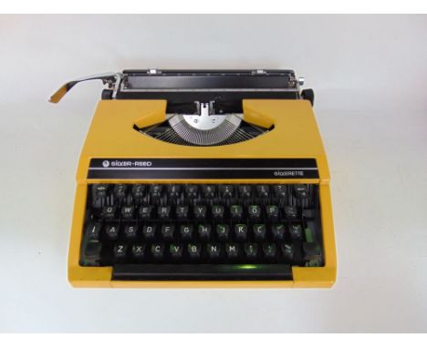 A vintage 'Silver-reed Silverette' cased typewriter in yellow, together with a box "brownie" camera